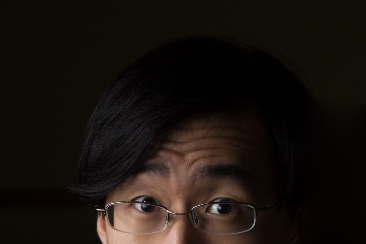 man in glasses black background